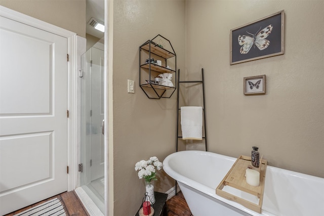 13043 W County Road 4182, Henderson, TX 75654 - full bath with a shower stall, wood finished floors, a freestanding tub, baseboards, and visible vents