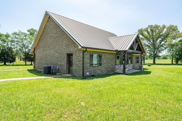 13043 W County Road 4182, Henderson, TX 75654 - view of home's exterior featuring a yard, cooling unit, a standing seam roof, brick siding, and metal roof