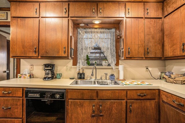 kitchen featuring a sink, light countertops, and black dishwasher