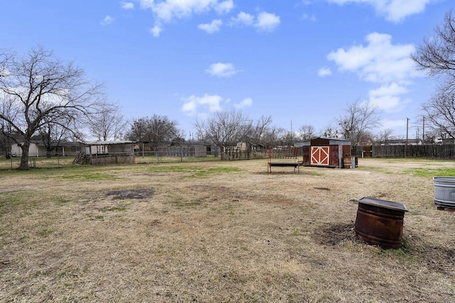 view of yard with fence, an outdoor structure, and a shed