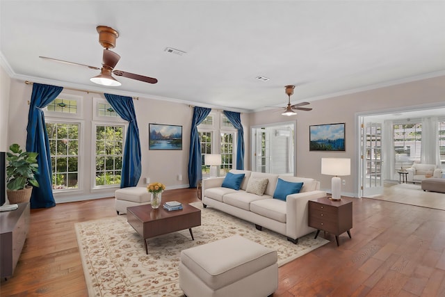 living room featuring hardwood / wood-style floors, visible vents, ornamental molding, and ceiling fan