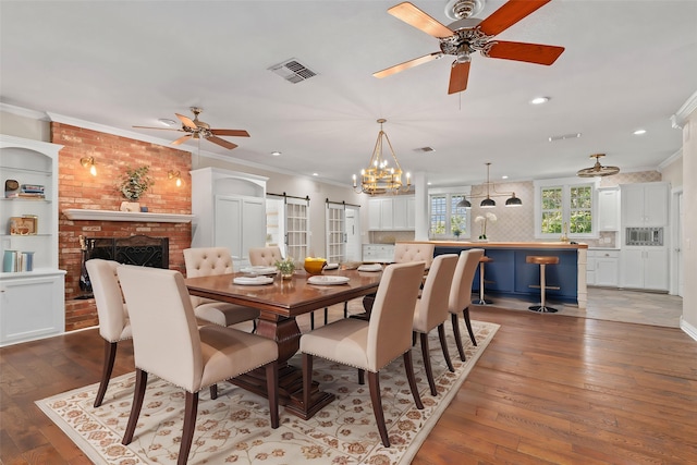 540 County Road 3341, Paradise, TX 76073 - dining space featuring a barn door, ceiling fan, ornamental molding, hardwood / wood-style flooring, and a brick fireplace