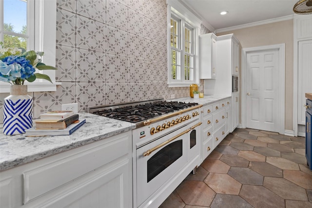 kitchen featuring backsplash, white cabinetry, ornamental molding, and double oven range