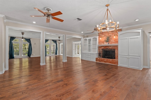 unfurnished living room featuring ornamental molding, wood finished floors, visible vents, and ceiling fan with notable chandelier