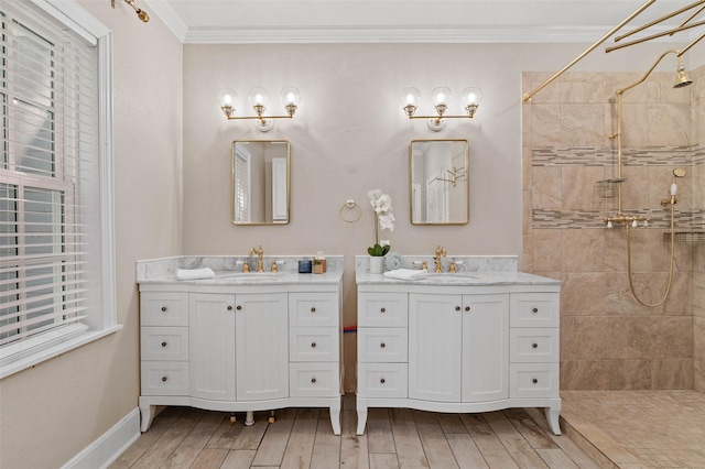 full bathroom with tiled shower, ornamental molding, a sink, and hardwood / wood-style floors