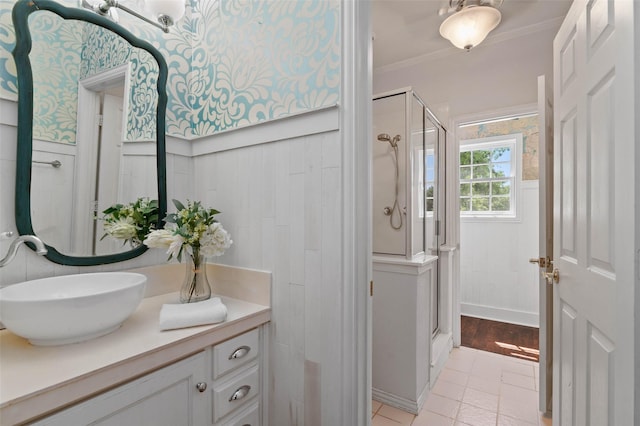 full bath featuring crown molding, vanity, a wainscoted wall, and a stall shower