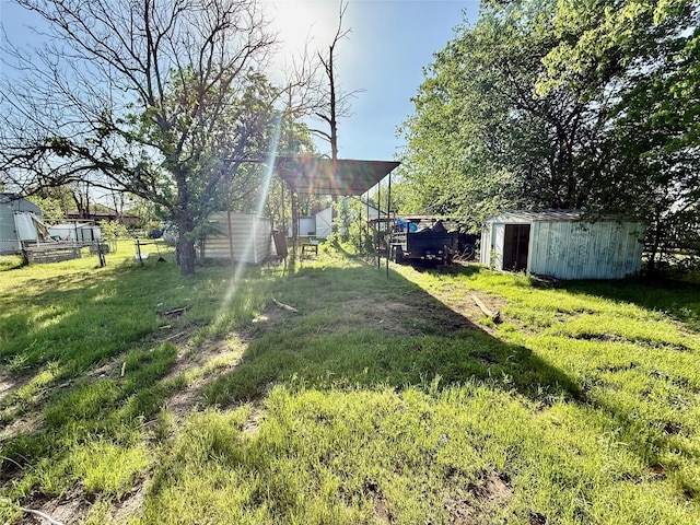 view of yard featuring fence, an outbuilding, and a shed