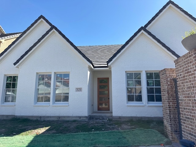 view of front of house featuring brick siding and a front lawn
