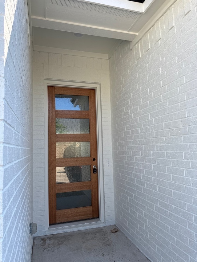 view of exterior entry with brick siding