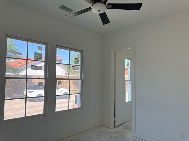 interior space featuring baseboards, a ceiling fan, and visible vents