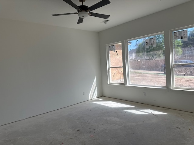 unfurnished room with unfinished concrete floors and a ceiling fan