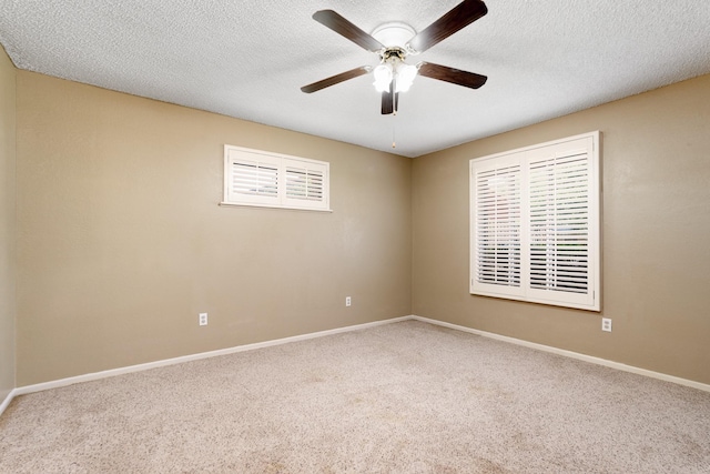 carpeted empty room featuring a ceiling fan, baseboards, and a textured ceiling