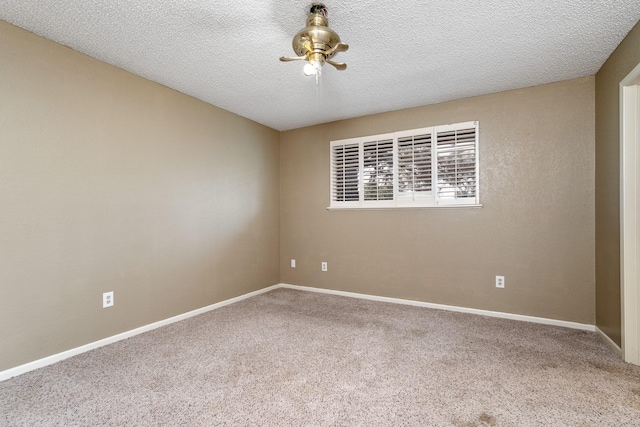 spare room featuring a textured ceiling, carpet flooring, baseboards, and a ceiling fan
