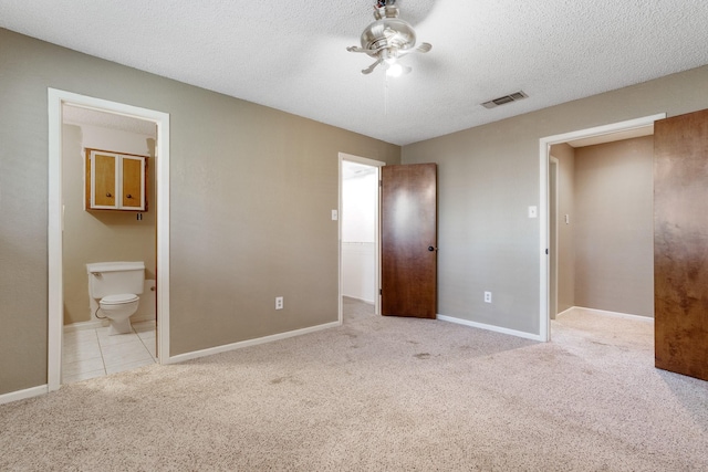 unfurnished bedroom featuring visible vents, baseboards, carpet floors, and a textured ceiling