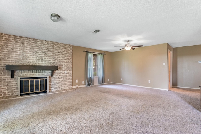 unfurnished living room featuring a textured ceiling, carpet floors, visible vents, a ceiling fan, and a fireplace
