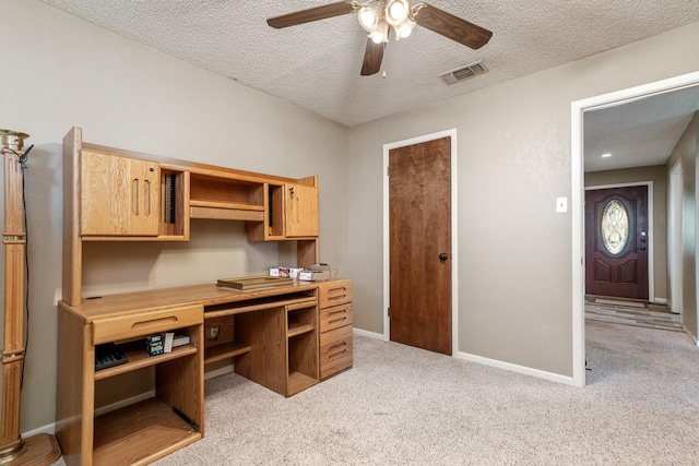 office with a ceiling fan, a textured ceiling, light carpet, baseboards, and visible vents