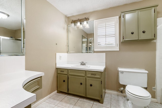 bathroom featuring a textured ceiling, vanity, a shower with shower door, baseboards, and toilet