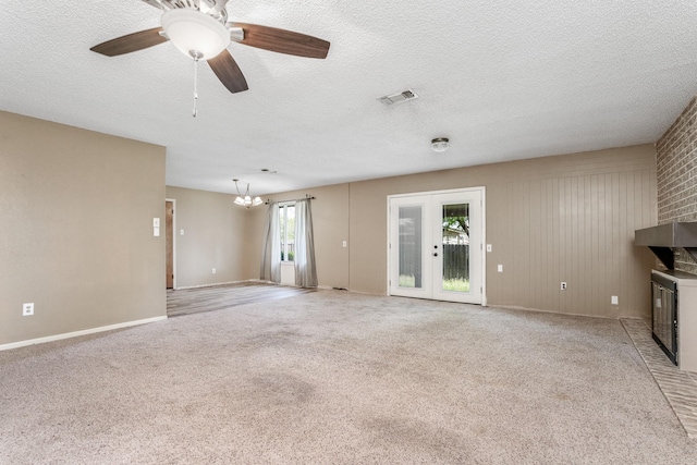 unfurnished living room featuring a textured ceiling, visible vents, baseboards, and light carpet