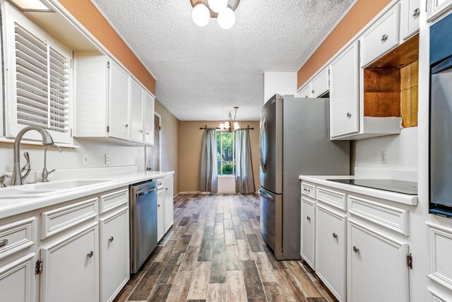 kitchen with a notable chandelier, stainless steel appliances, light countertops, and a sink