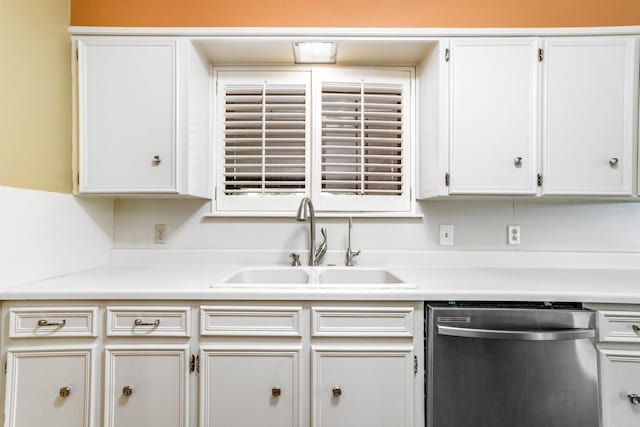 kitchen with light countertops, dishwasher, white cabinetry, and a sink