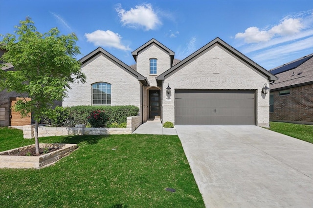 french country style house with concrete driveway, a front lawn, and a garage