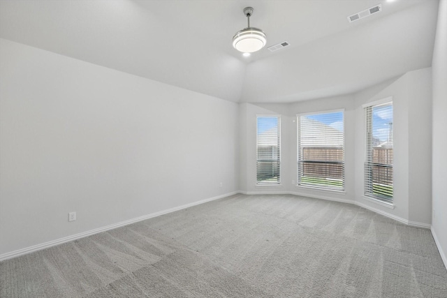 carpeted spare room with baseboards, visible vents, and a healthy amount of sunlight