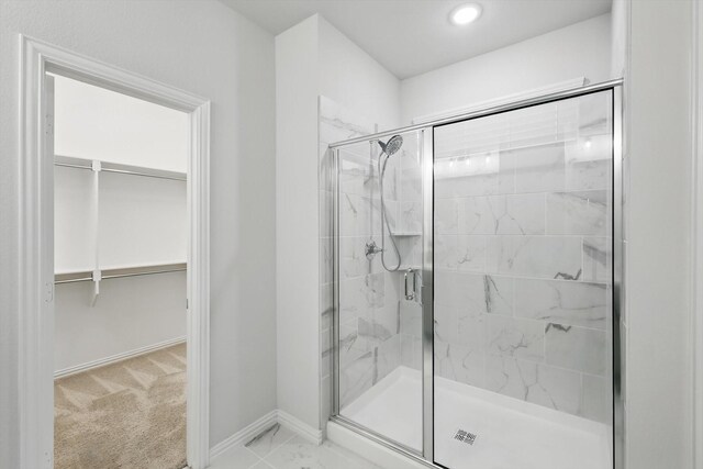 bathroom with a shower stall, baseboards, a walk in closet, and recessed lighting