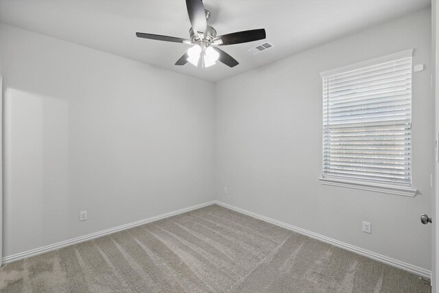 spare room featuring baseboards, visible vents, carpet, and ceiling fan