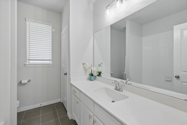 bathroom featuring tile patterned flooring, vanity, toilet, and baseboards