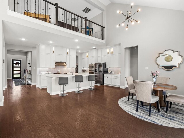 178 Dundee Ct, Argyle, TX 76226 - dining area featuring baseboards, visible vents, a chandelier, a high ceiling, and dark wood-type flooring