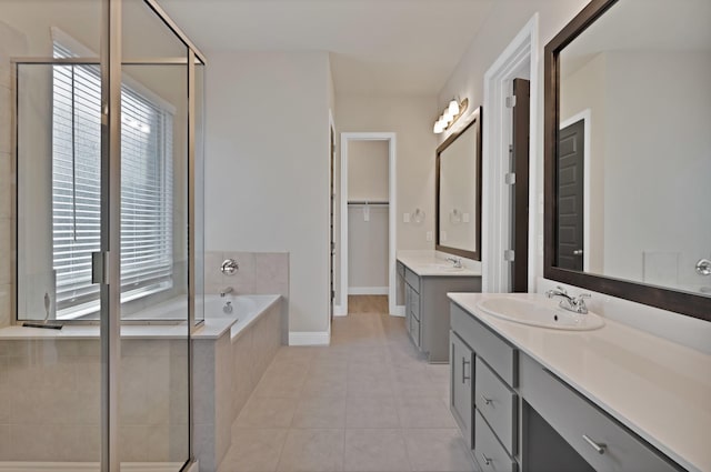bathroom with two vanities, a garden tub, tile patterned floors, and a sink
