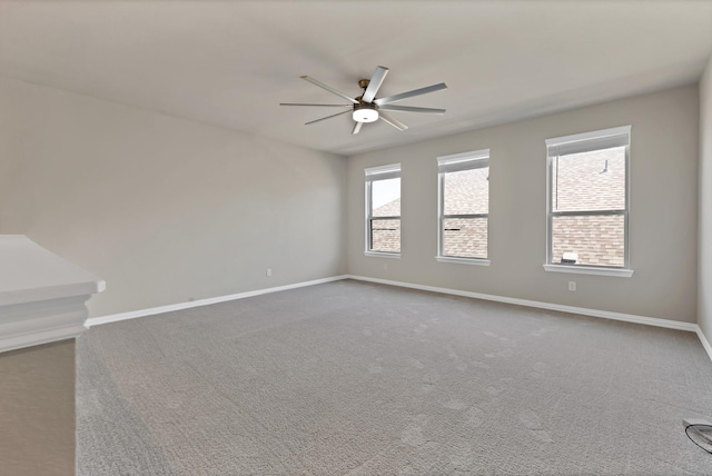 unfurnished room with a ceiling fan, baseboards, and carpet