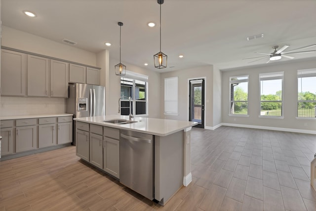 kitchen with appliances with stainless steel finishes, gray cabinetry, and visible vents