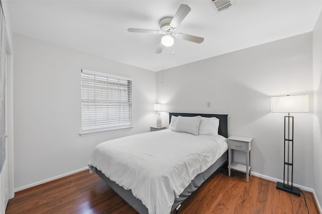bedroom featuring wood finished floors, visible vents, ceiling fan, and baseboards