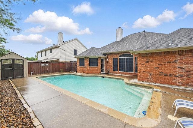 view of swimming pool with a fenced backyard, an outdoor structure, a fenced in pool, a patio area, and a shed