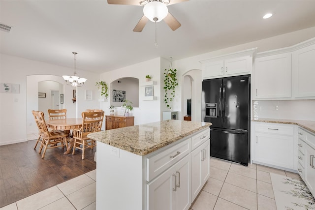 3450 County Road 2156, Caddo Mills, TX 75135 - kitchen featuring black refrigerator with ice dispenser, arched walkways, a ceiling fan, a kitchen island, and light tile patterned flooring
