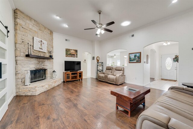3450 County Road 2156, Caddo Mills, TX 75135 - living room featuring a ceiling fan, arched walkways, ornamental molding, a fireplace, and wood finished floors