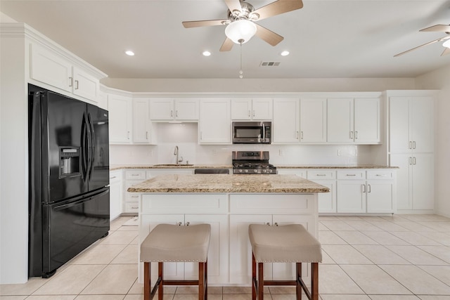 3450 County Road 2156, Caddo Mills, TX 75135 - kitchen with appliances with stainless steel finishes, a ceiling fan, a sink, white cabinetry, and a center island