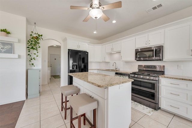 3450 County Road 2156, Caddo Mills, TX 75135 - kitchen featuring appliances with stainless steel finishes, a sink, white cabinetry, light tile patterned floors, and a center island