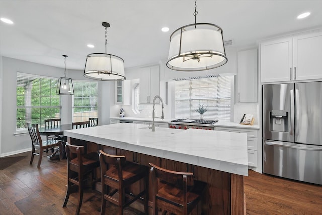 kitchen with dark wood finished floors, stainless steel refrigerator with ice dispenser, a sink, and recessed lighting