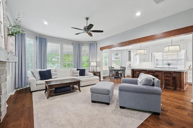 living room with a wealth of natural light, a ceiling fan, dark wood-style flooring, and recessed lighting