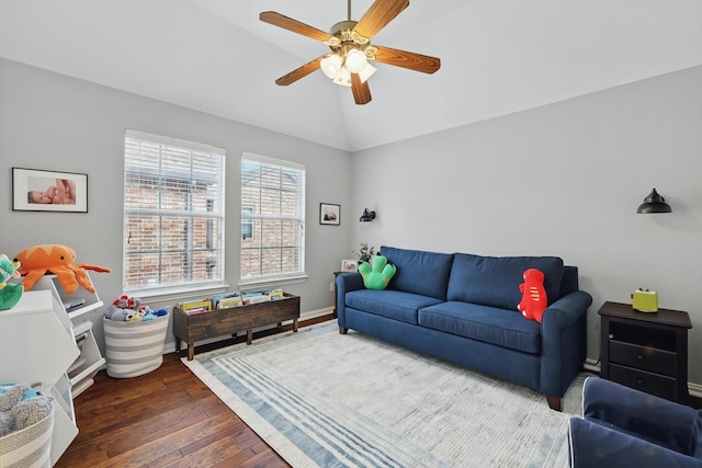 living room featuring vaulted ceiling, a ceiling fan, baseboards, and wood finished floors