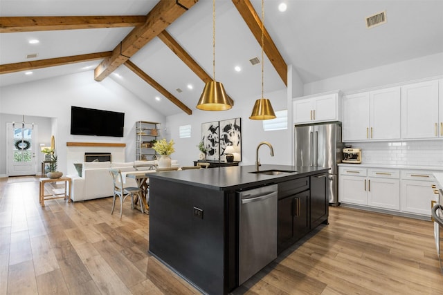 13645 Sweetwalk Pl, Fort Worth, TX 76008 - kitchen featuring a sink, appliances with stainless steel finishes, beam ceiling, light wood-type flooring, and a center island with sink