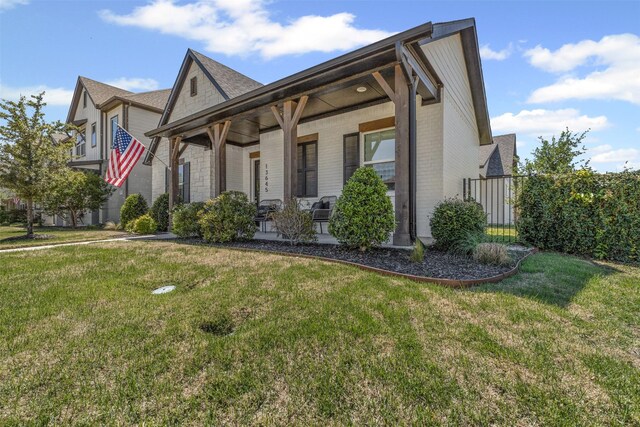 13645 Sweetwalk Pl, Fort Worth, TX 76008 - view of front of home with brick siding, a front yard, and a porch