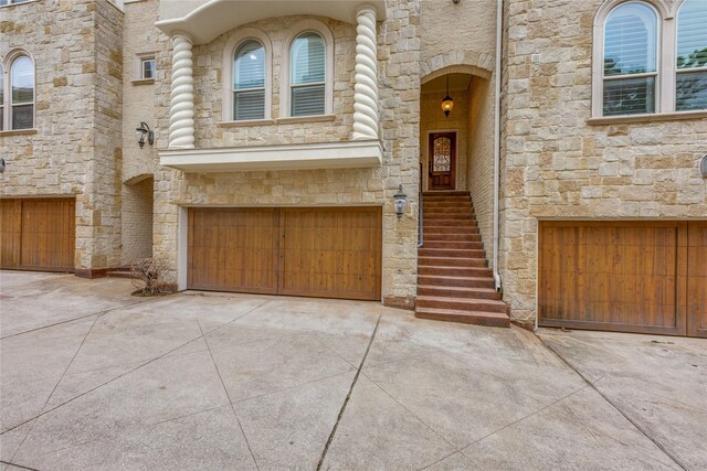 3907 Cole Ave Unit 5, Dallas, TX 75204 - doorway to property with an attached garage, driveway, and stone siding