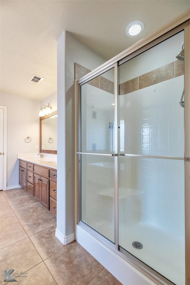 7018 Waterway Ln, Abilene, TX 79606 - full bathroom with tile patterned flooring, double vanity, visible vents, and a stall shower