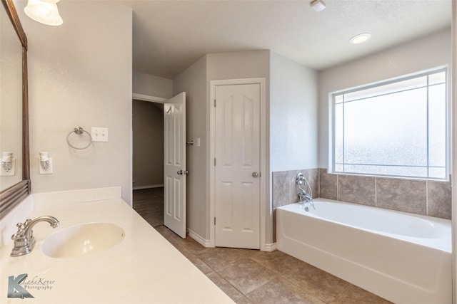 7018 Waterway Ln, Abilene, TX 79606 - bathroom featuring baseboards, a garden tub, tile patterned flooring, and vanity