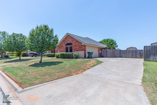7018 Waterway Ln, Abilene, TX 79606 - view of front of home featuring concrete driveway, an attached garage, fence, a front yard, and brick siding