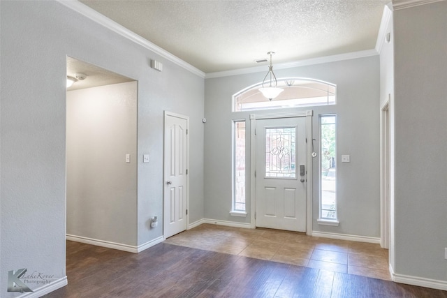 7018 Waterway Ln, Abilene, TX 79606 - entryway with wood finished floors, a textured ceiling, baseboards, and ornamental molding