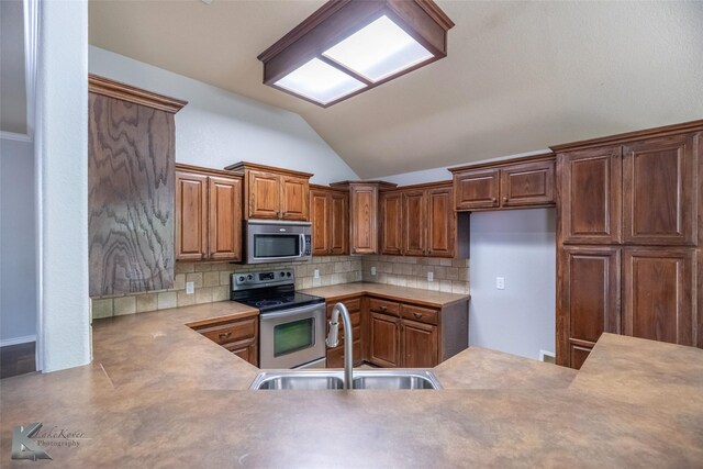 7018 Waterway Ln, Abilene, TX 79606 - kitchen featuring tasteful backsplash, a sink, stainless steel appliances, light countertops, and lofted ceiling